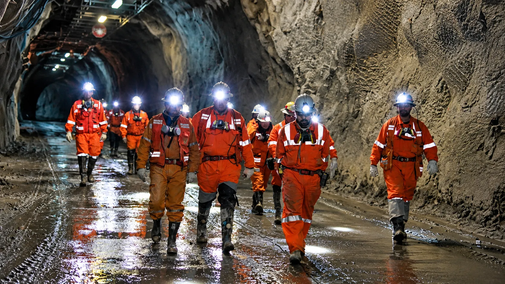 Mineros en túnel subterráneo húmedo